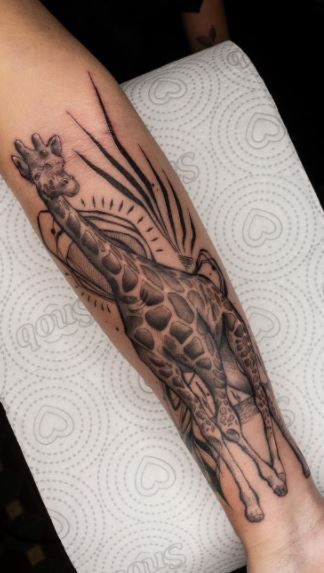 Tattoo of a giraffe on the forearm for women