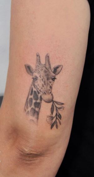 Tattoo of a giraffe on the shoulder for women