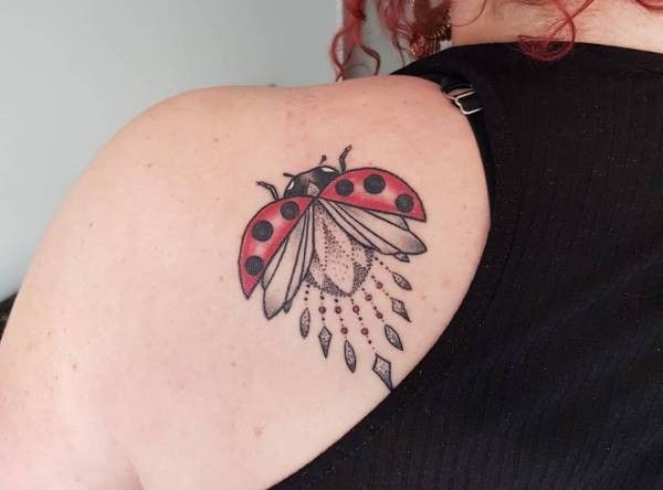 Ladybug tattoo on the shoulder blade for women