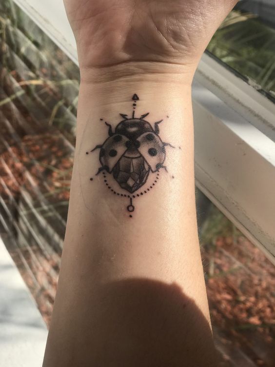 Ladybug tattoo on the arm for women