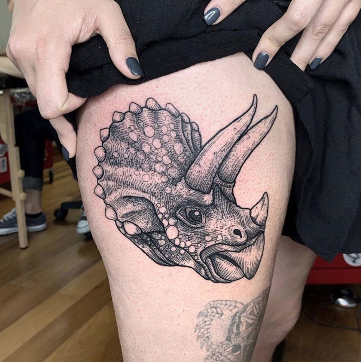 Dinosaur tattoo on the hip for women