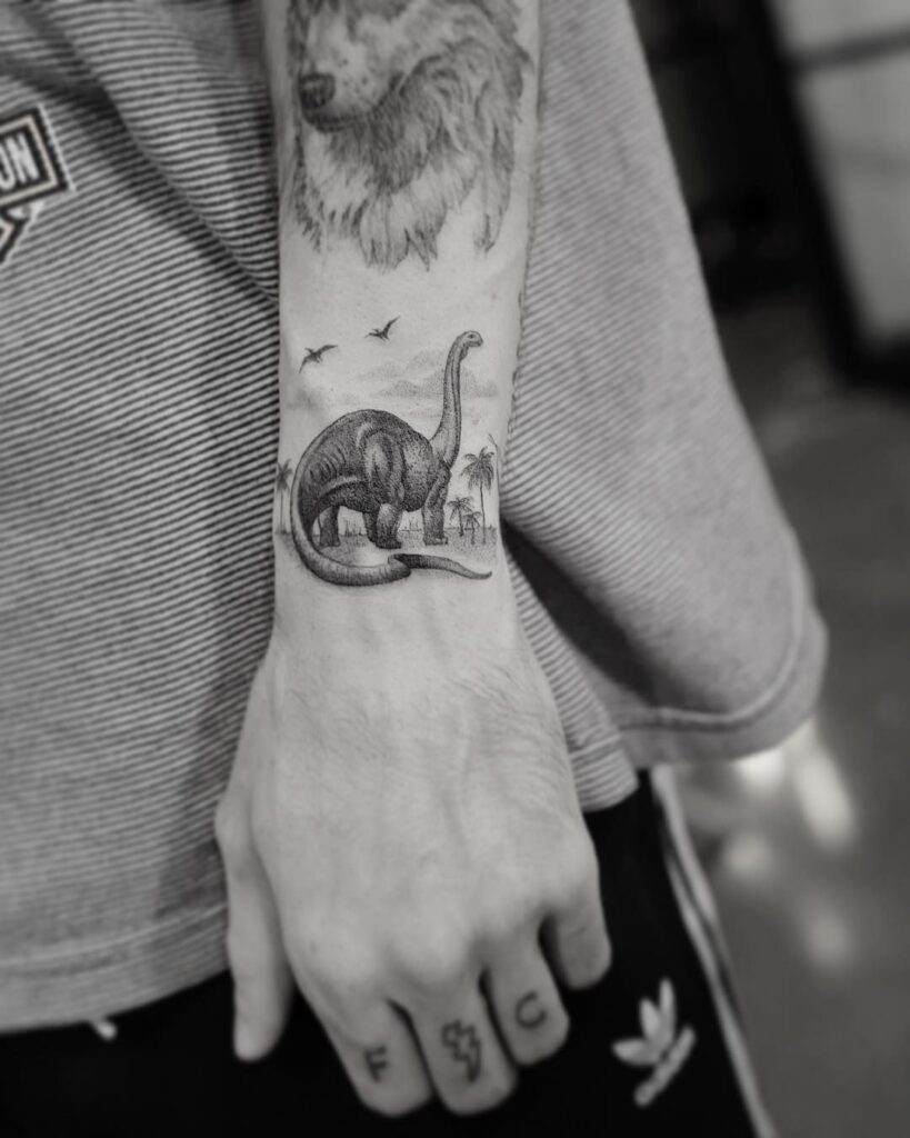 Tattoo of a dinosaur on the wrist for men