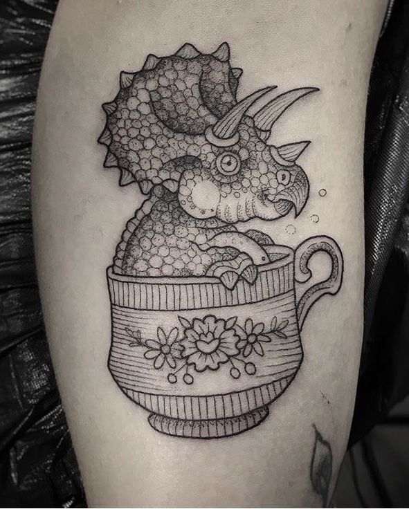 Tattoo of a dinosaur on the leg for women