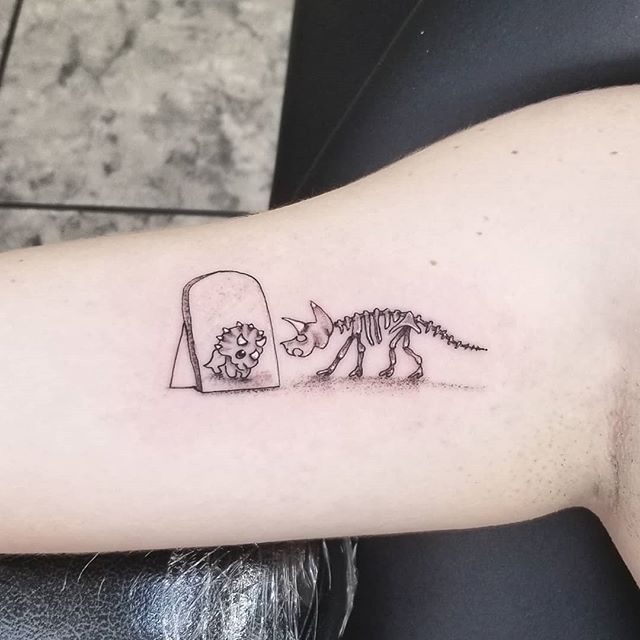 Tattoo of a dinosaur on the arm for women