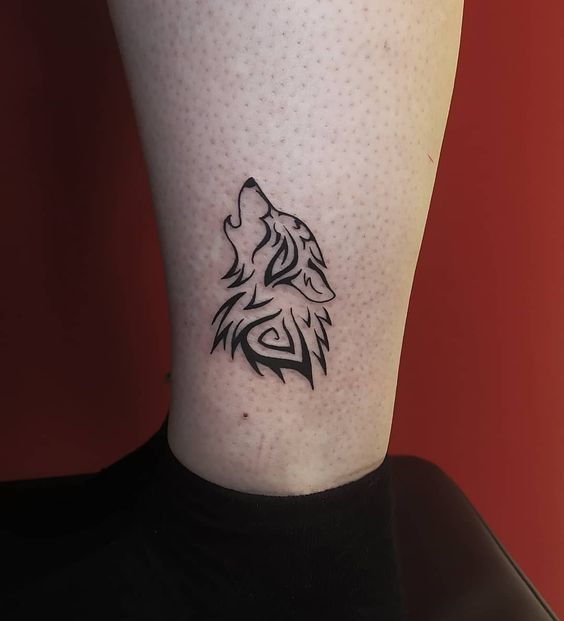 Tattoo of a wolf on the shin for men