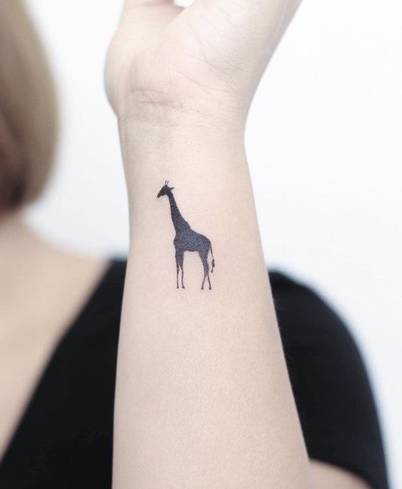 Tattoo of a giraffe on the arm for women