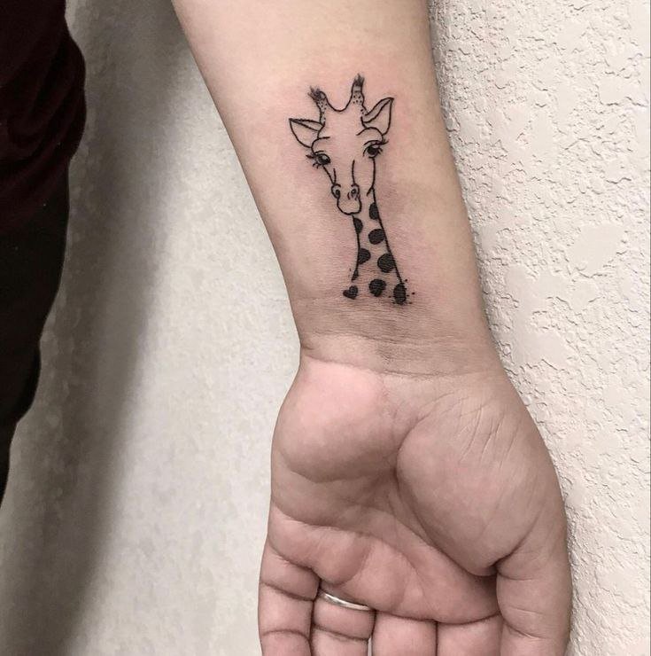 Tattoo of a giraffe on the wrist for women