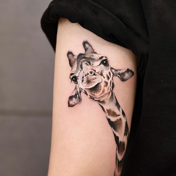 Tattoo of a giraffe on the shoulder for women