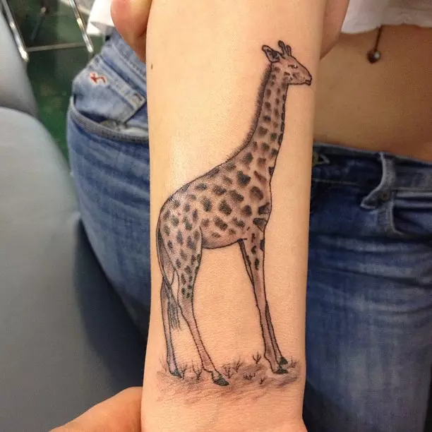 Tattoo of a giraffe on the arm for women