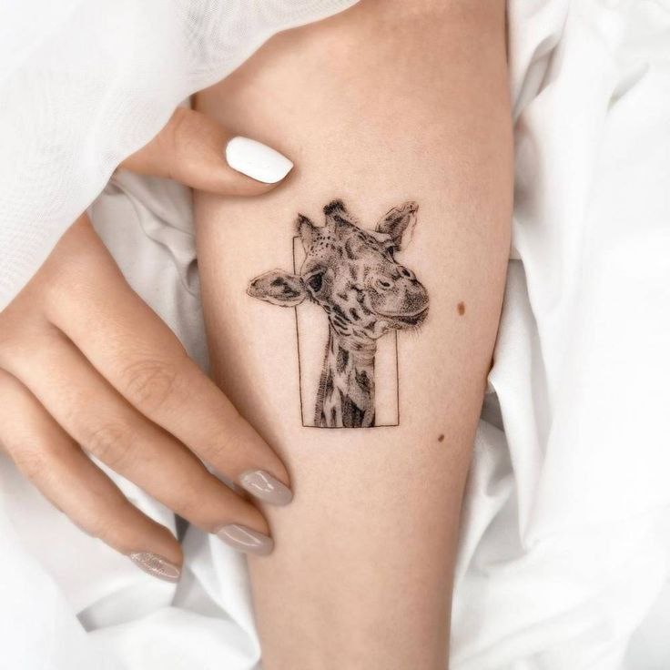 Tattoo of a giraffe on the forearm for women