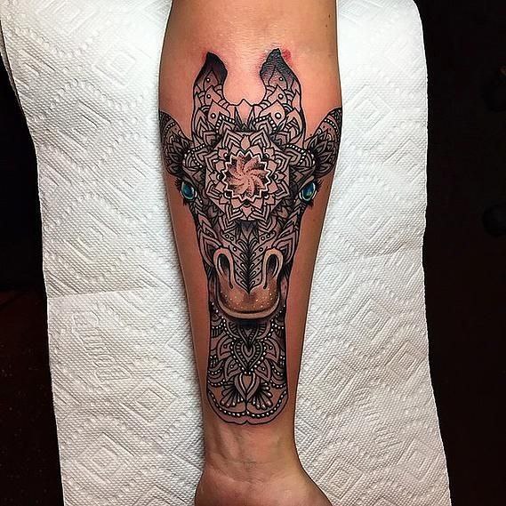 Tattoo of a giraffe on the arm for women