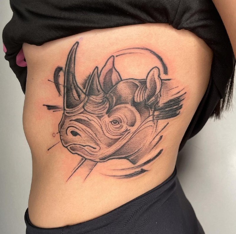 Rhinoceros tattoo on the side for women