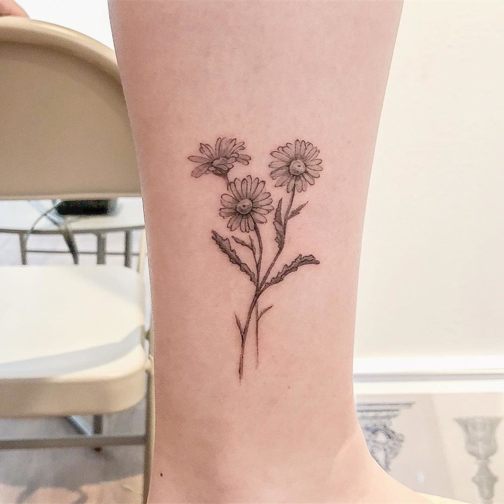 Daisy tattoo on the shin for women