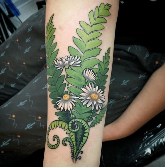 Colorful tattoo of a daisy with a fern on the forearm for women