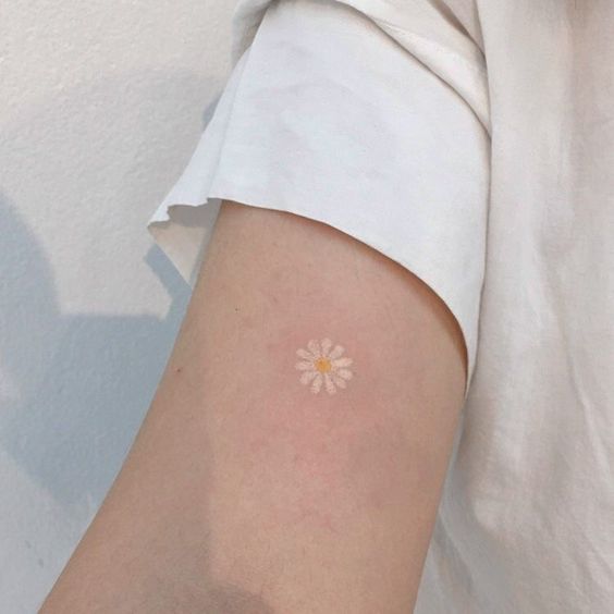 Small daisy tattoo on the shoulder for women