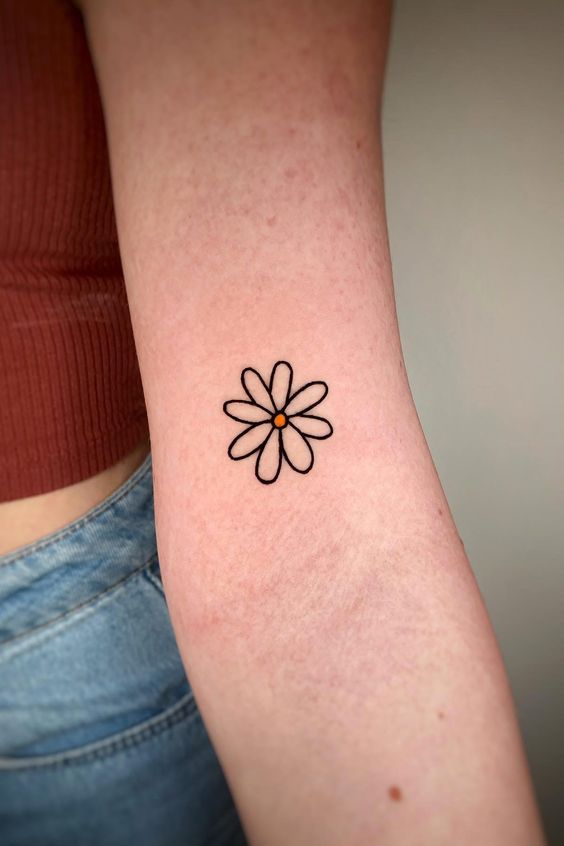 Small daisy tattoo on the shoulder for women