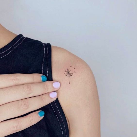 Small tattoo of a dandelion on the shoulder for women