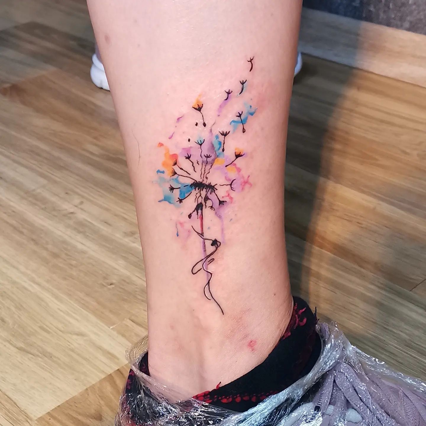 Colored dandelion tattoo on the shin for men