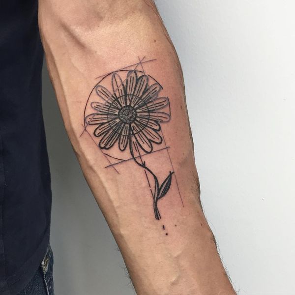 Large daisy tattoo on the forearm for women