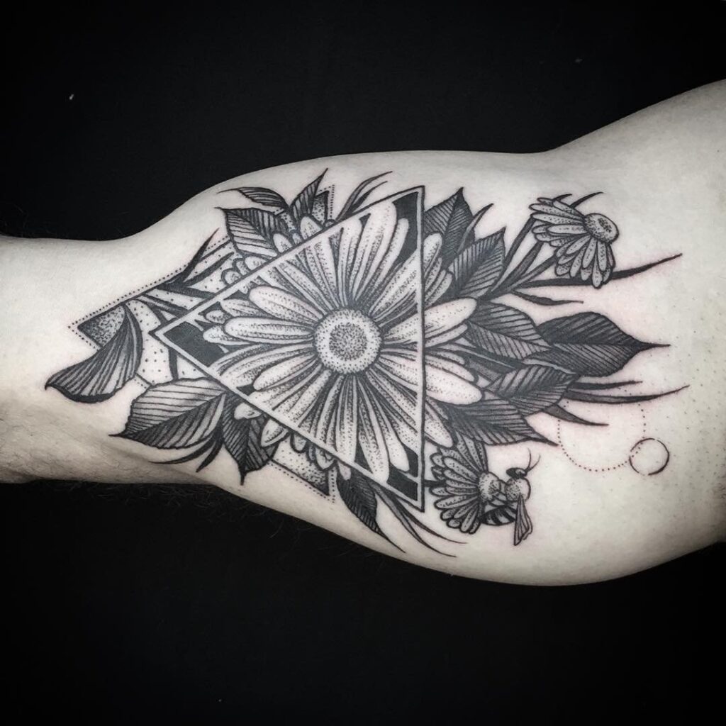 Large daisy tattoo on the biceps for men