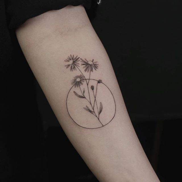 Daisy tattoo on forearm for women