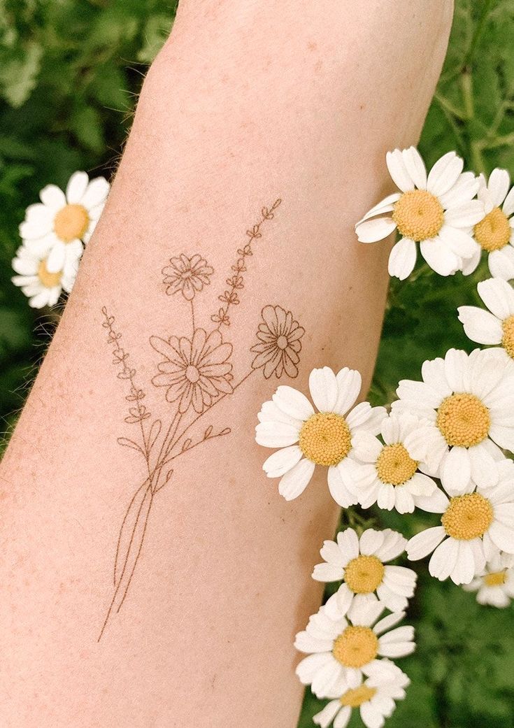 Daisy tattoo on forearm for women