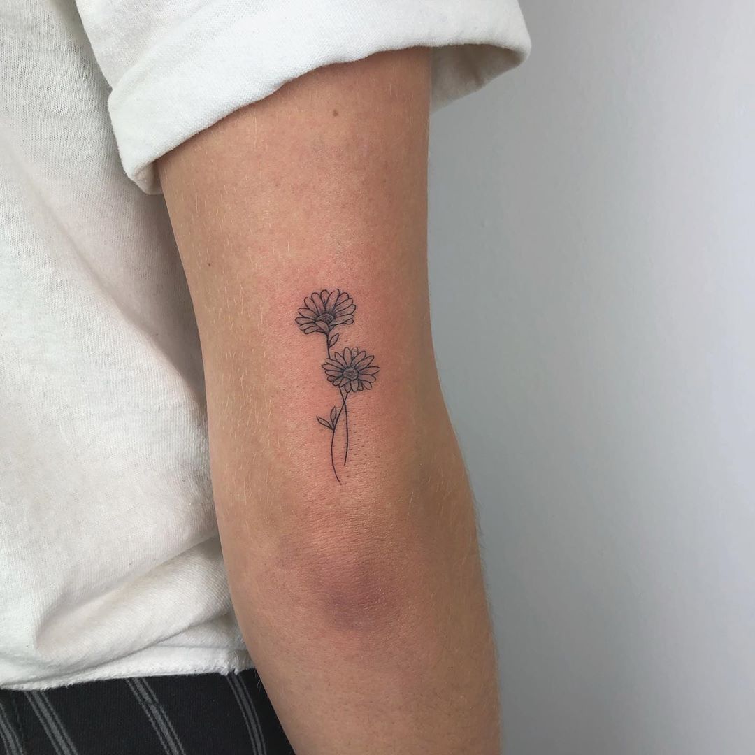 Small daisy tattoo on the shoulder for women