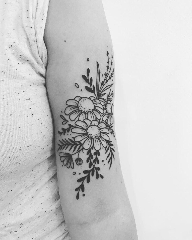 Daisy tattoo on the shoulder for women