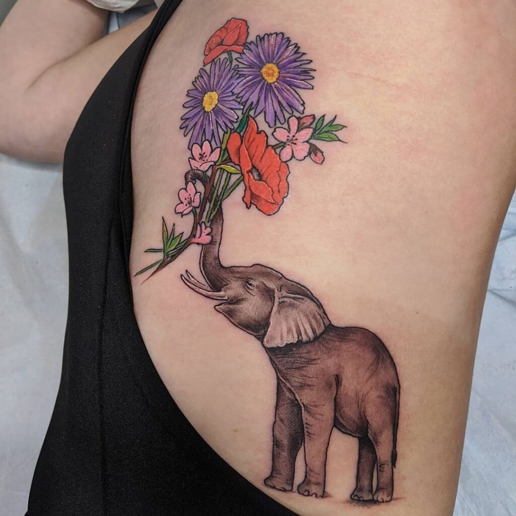 Elephant tattoo with flowers on the side for women