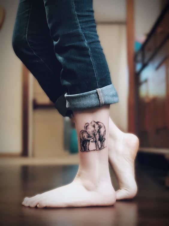 Tattoo of two elephants on the shin for women