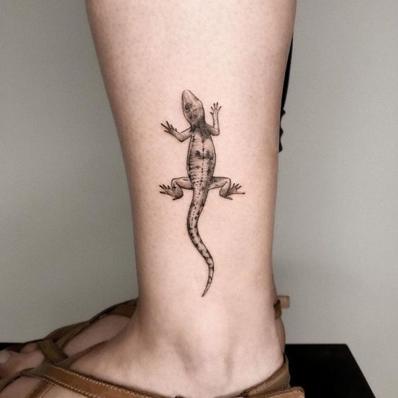 Lizard tattoo on the shin for women