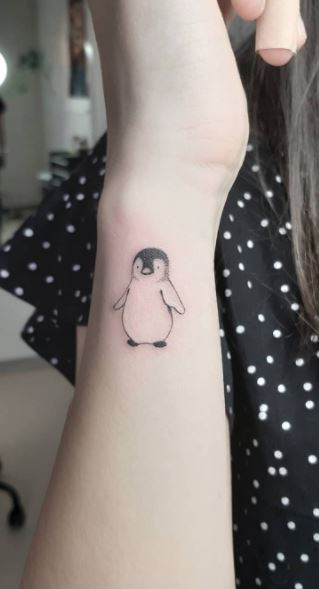 Tattoo of a penguin on the arm for women