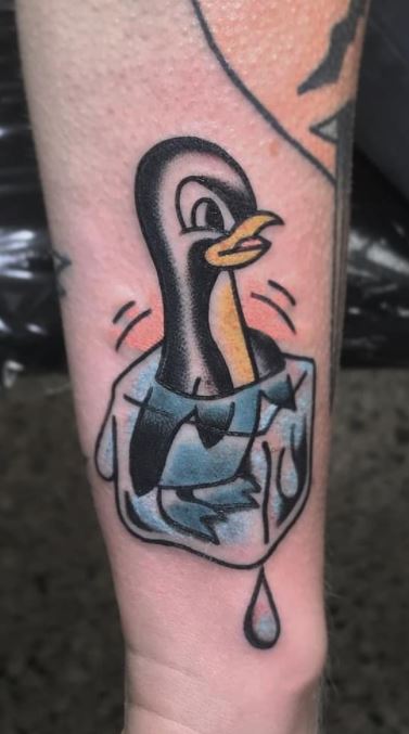 Tattoo of a penguin on the arm for men