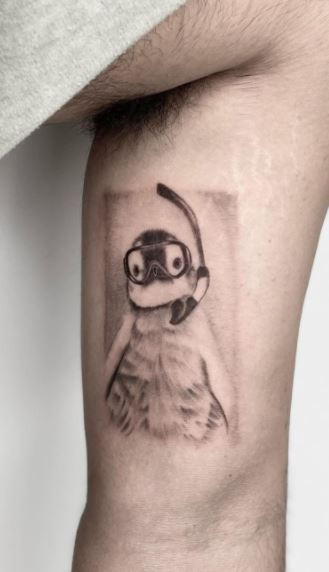 Tattoo of a penguin on the bicep for men