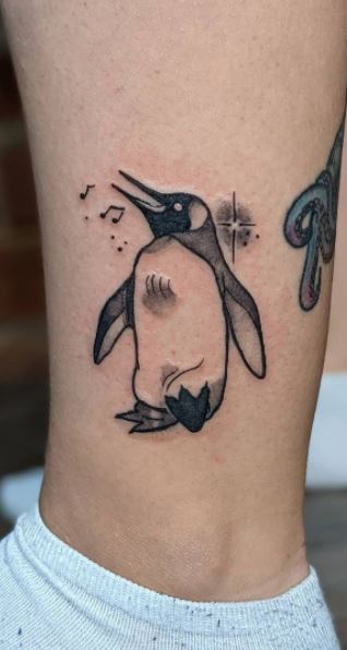 Tattoo of a penguin on the shin for men