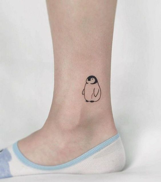 Tattoo of a penguin on the leg for women