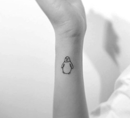 Tattoo of a penguin on the arm for women