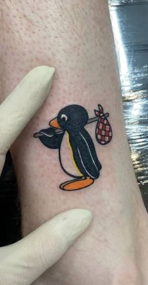 Tattoo of a penguin on the shin for men