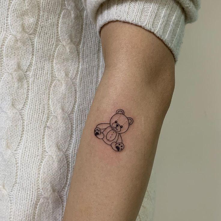 Tattoo of a toy bear on the forearm for women