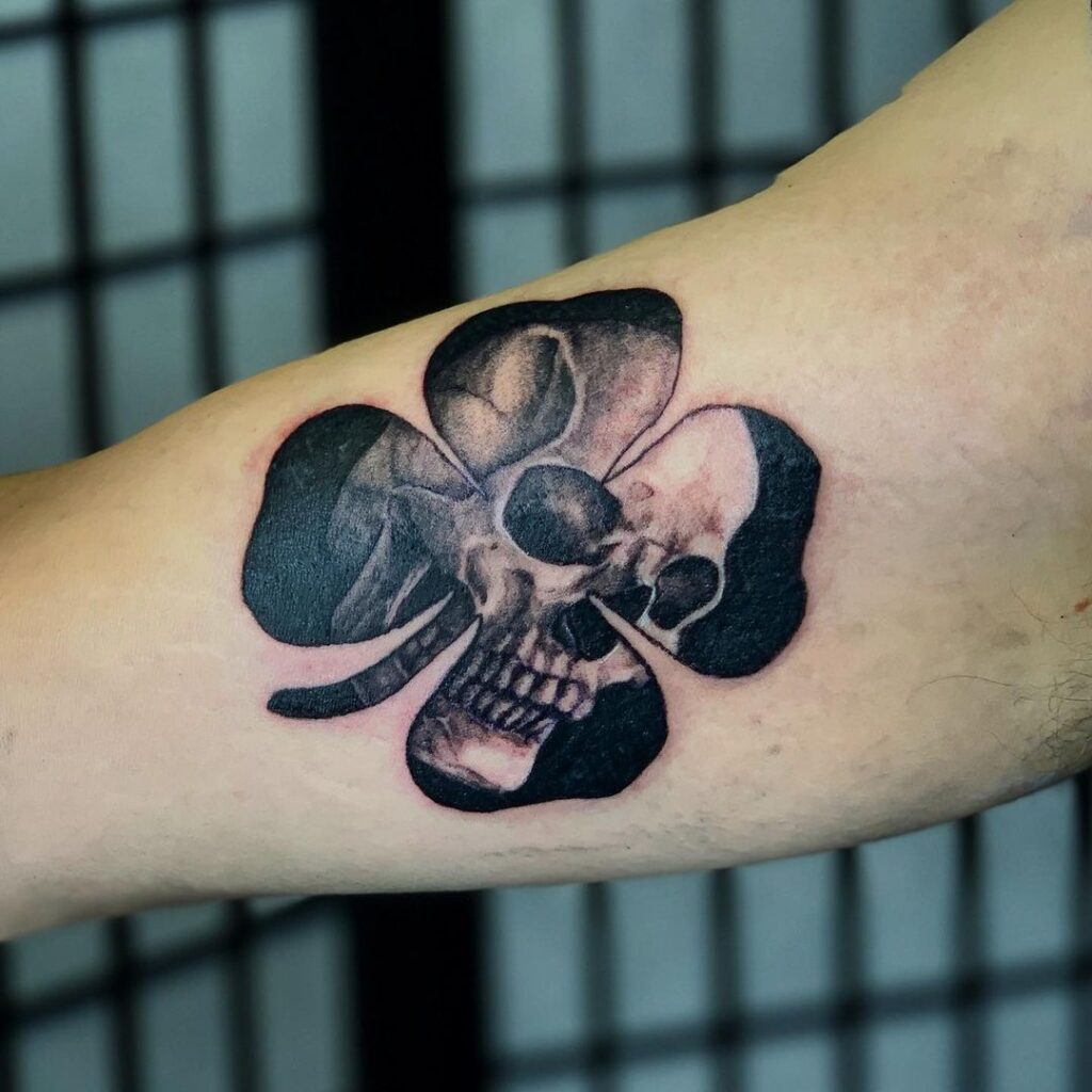 Tattoo of a clover with a skull on the shoulder for men