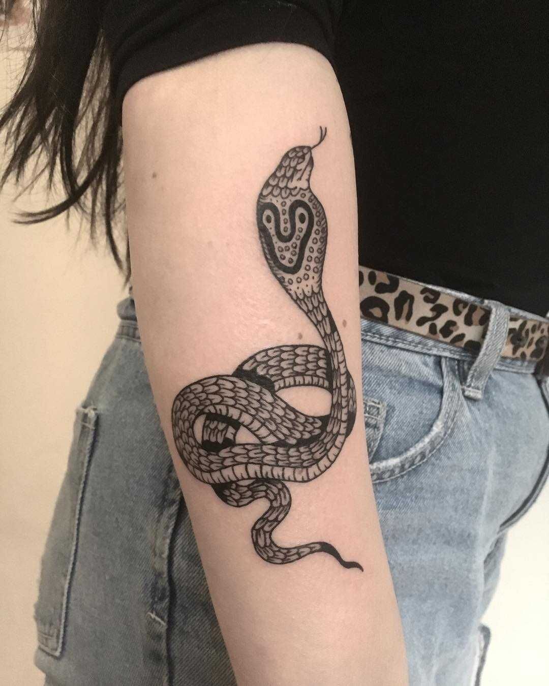 Cobra tattoo on the arm for women