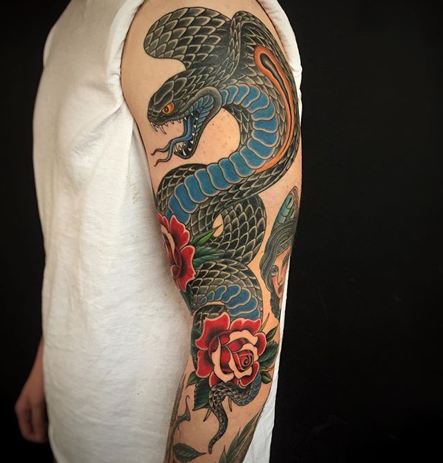 Tattoo of a colored cobra on the arm for men