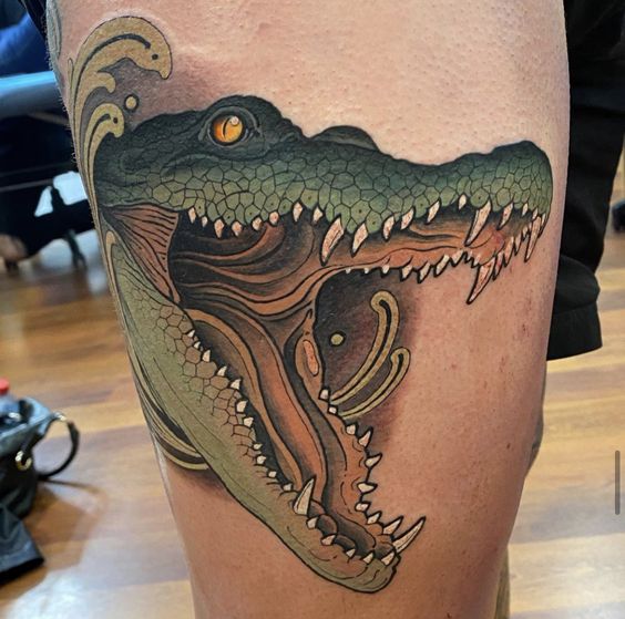 Tattoo of a colored crocodile on the thigh for men