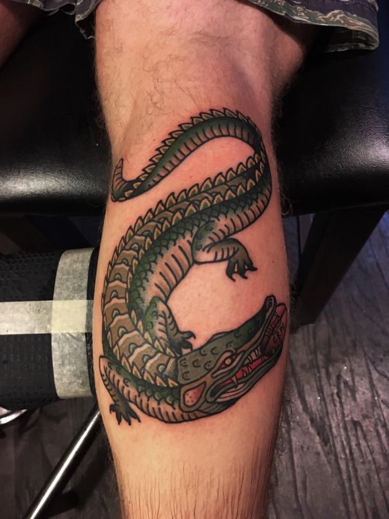 Tattoo of a colored crocodile on a calf for men