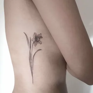 Daffodil flower tattoo on the side for women