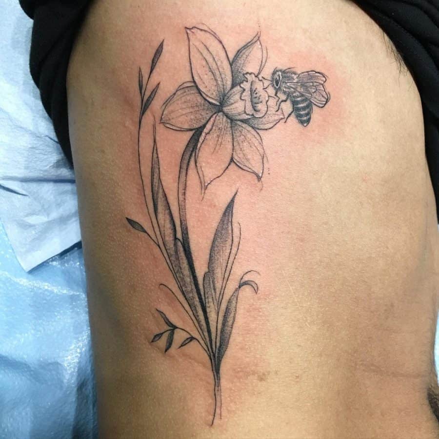 Daffodil flower and wasp tattoo on the side for men