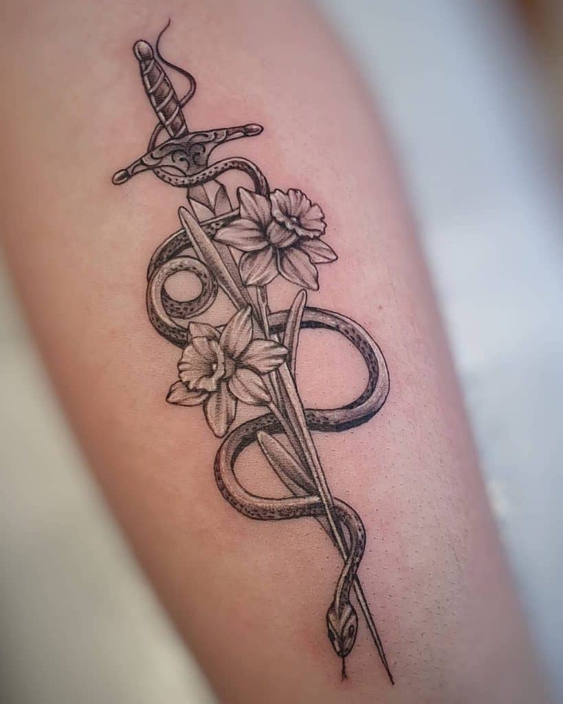 Daffodil flower and dagger tattoo on forearm for women