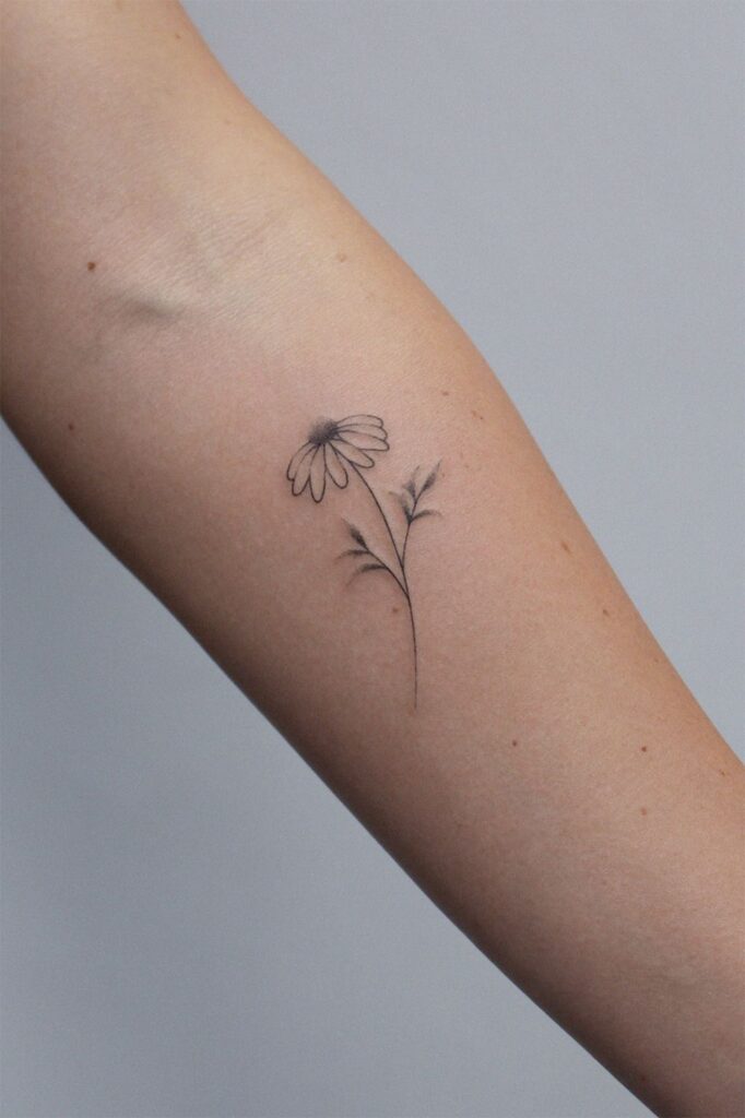 Daisy tattoo on forearm for women