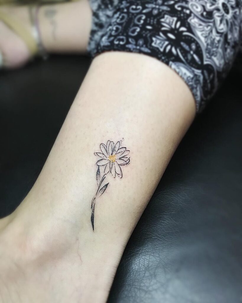 Daisy tattoo on the shin for women