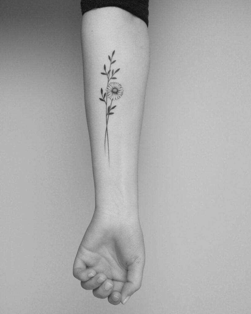 Daisy tattoo on forearm for women